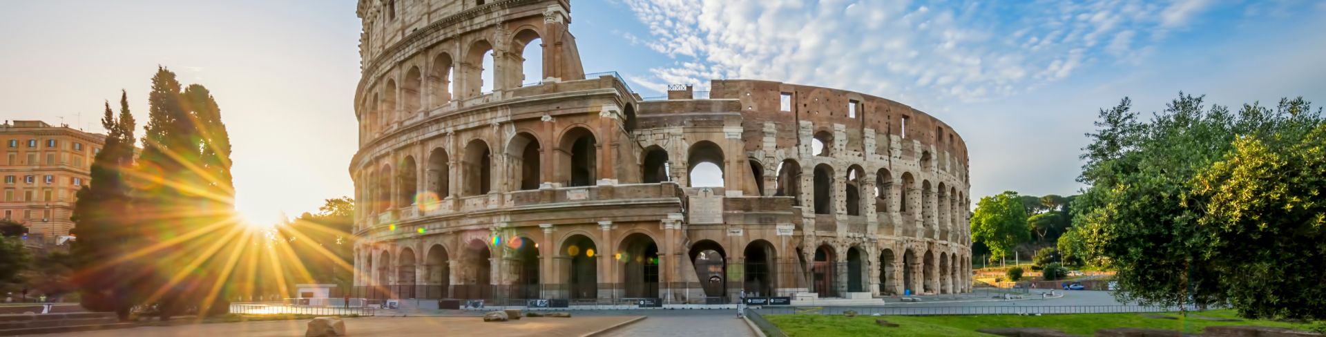 The sun sets behind the Colosseum. 