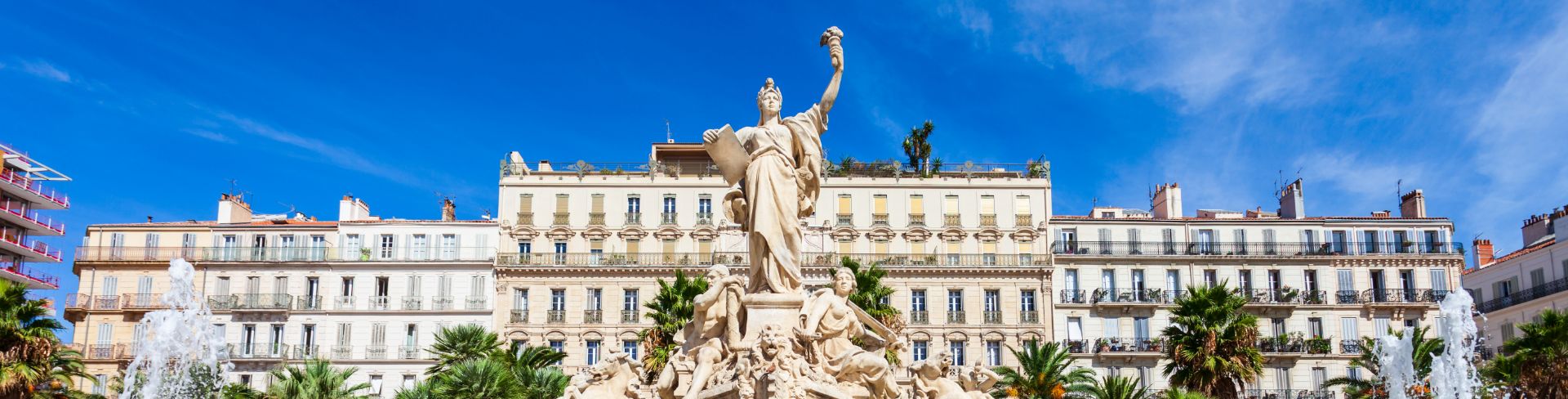 A statue stands in the center of a water fountain in Toulon, France.