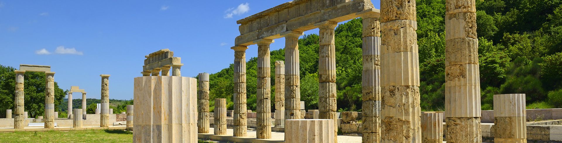 Old stone columns sit lining a walkway.