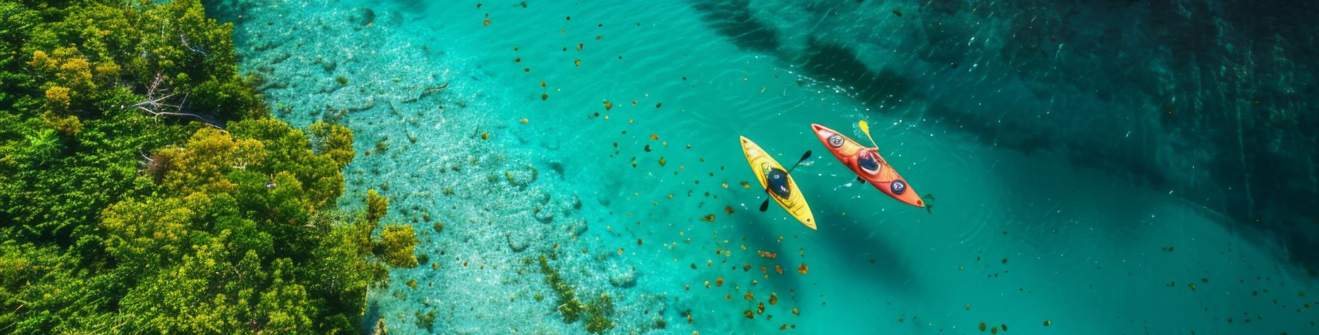 Three kayaks float atop crystal clear waters. 