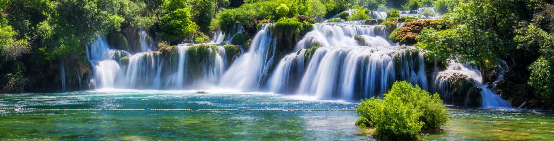 Trees line a waterfall in Trogir, Croatia.