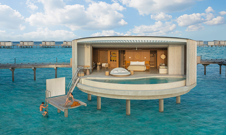 A Ritz Carlton Villa in the Maldives sits over bright blue waters.