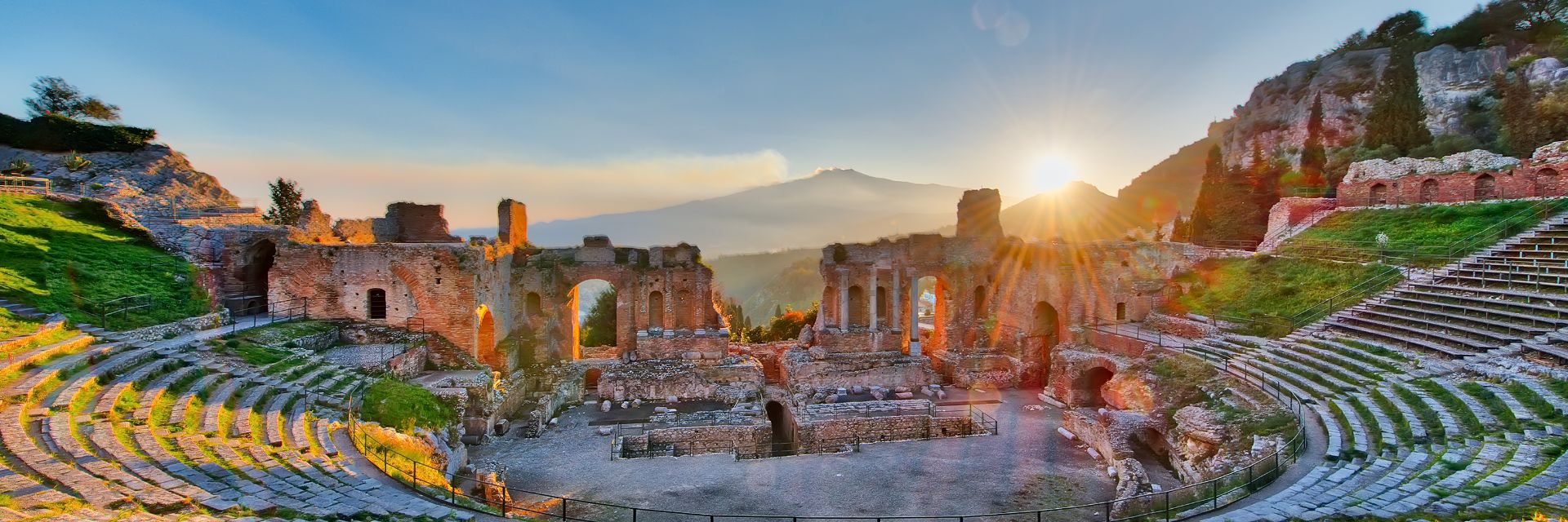 Sunbeams cascade across the Teatro Antico di Taormina ruins in Italy.