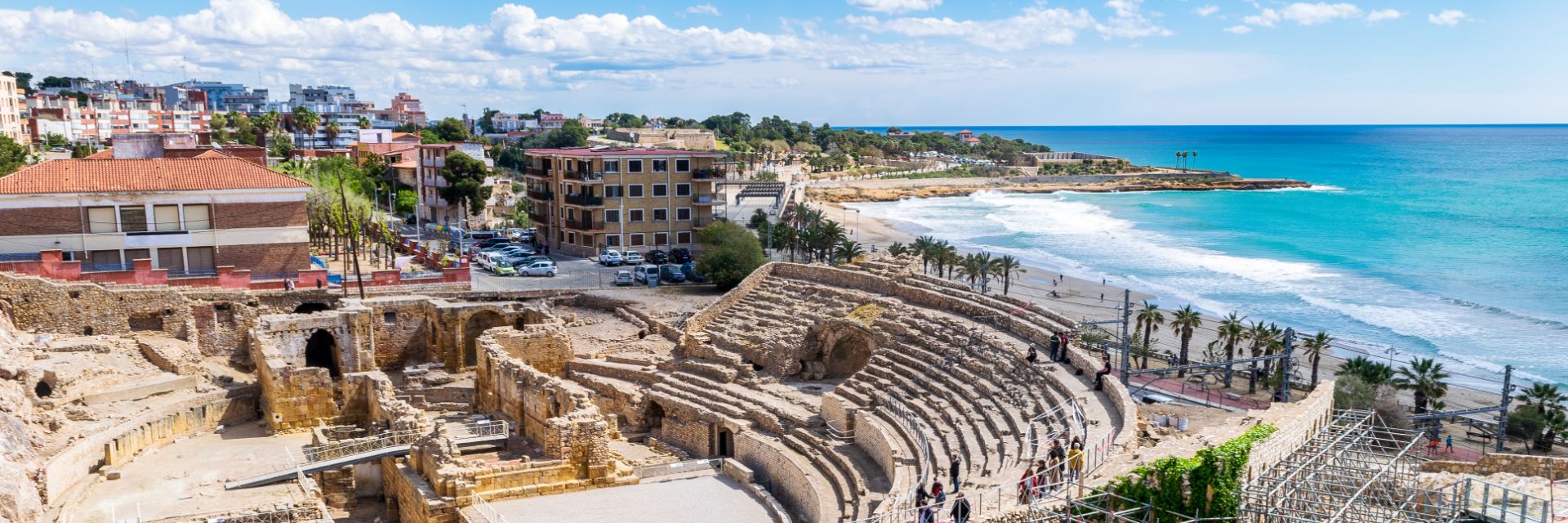 An ancient amphitheater sits ocean side. 