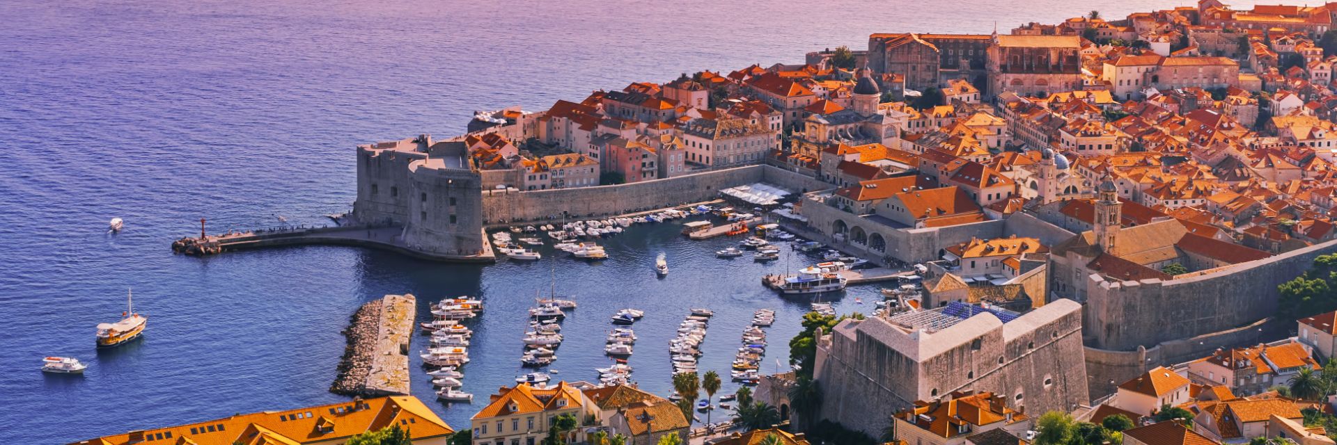 The sun sets over a waterfront town.