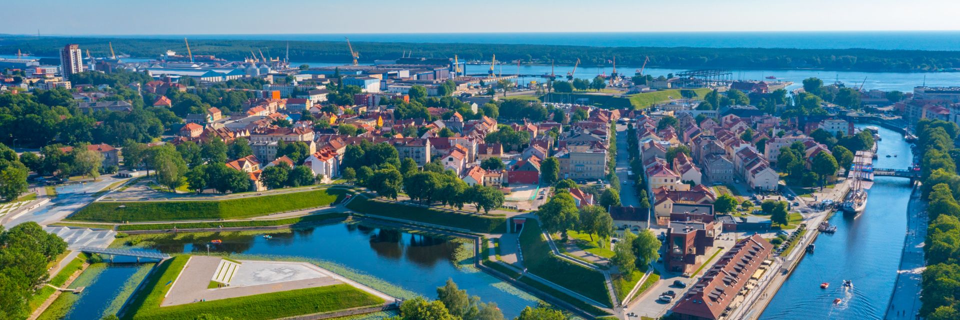 The sun shines on a small town with calm waterways running throughout.