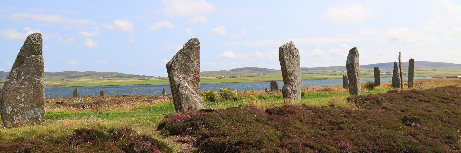 Stones stand in a circle formation on deep green grasses.