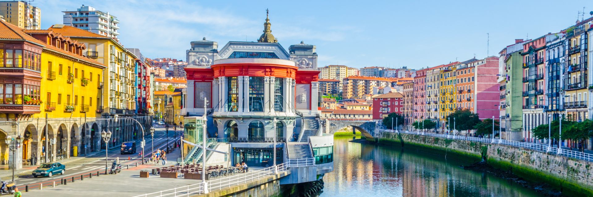 Colorful buildings line a calm waterway.
