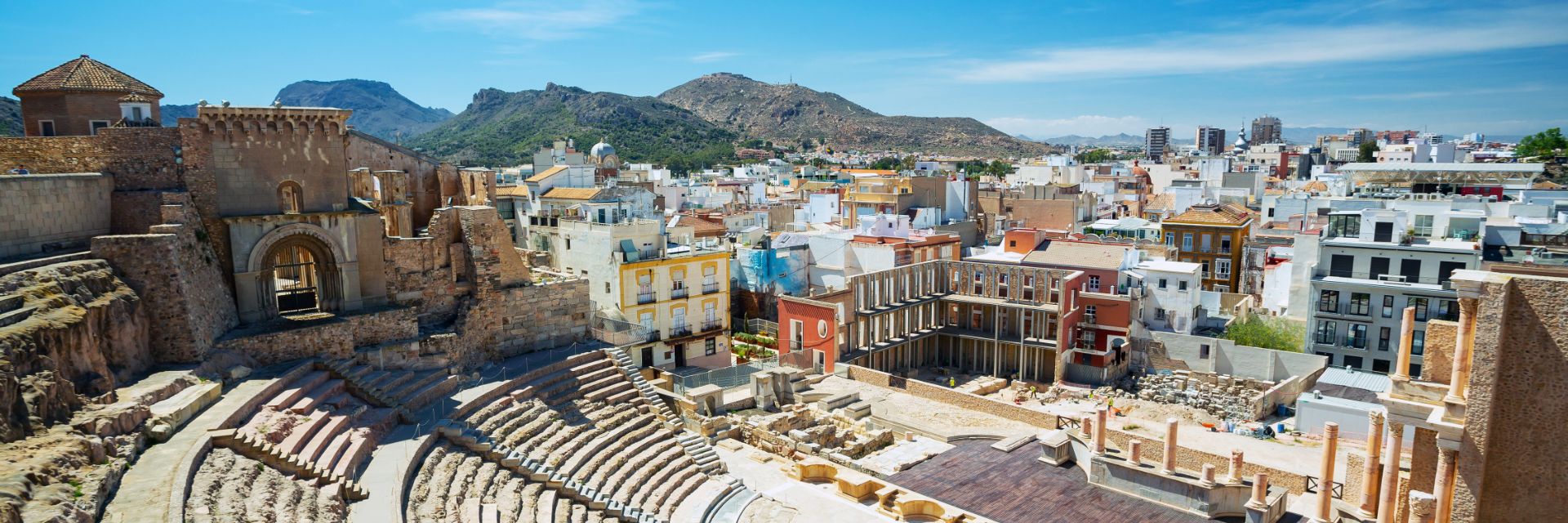 An old amphitheater overlooks a collection on buildings. 
