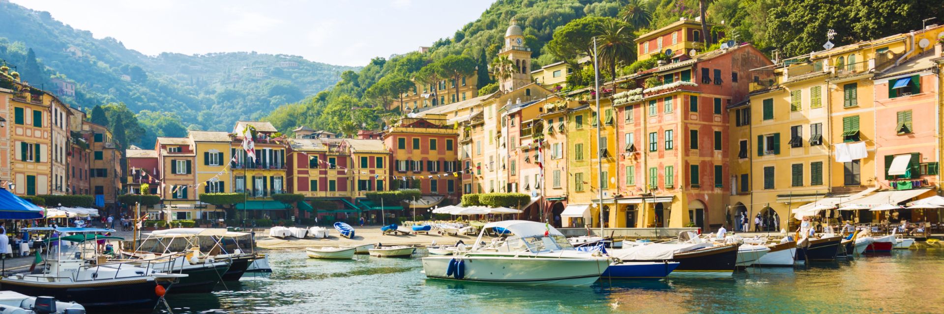 Buildings line a bright blue waterway filled with boats.