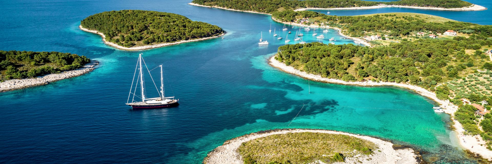 Small, tree covered islands dot a bright blue waterway. 