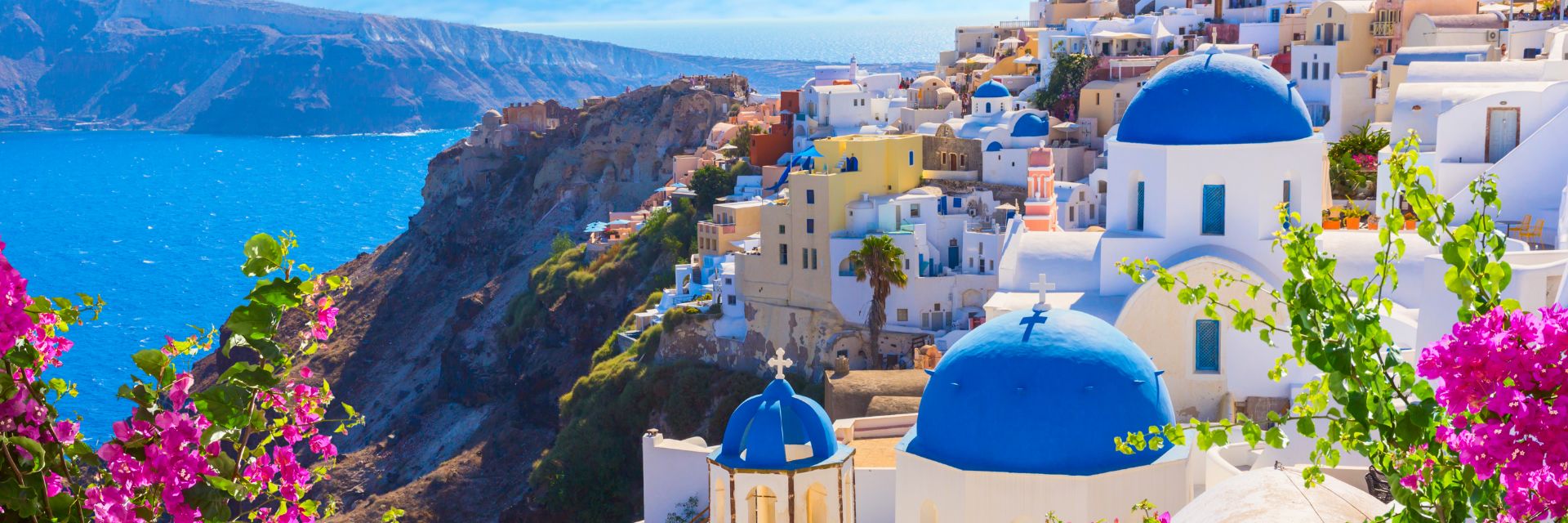Blue rooftops cover bright white buildings on a mountainside.