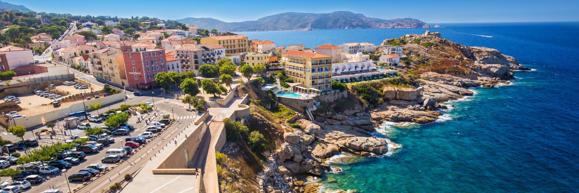 Bright blue waters meet a collection of stone buildings.