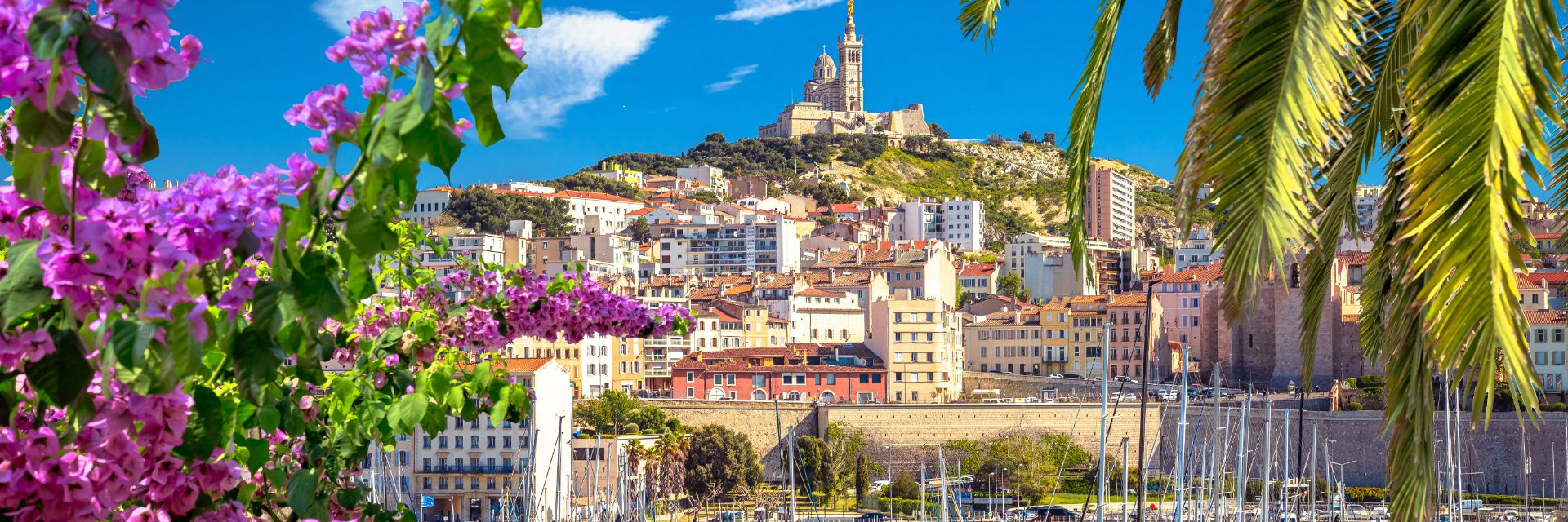 Buildings climb a hillside under bright blue skies.