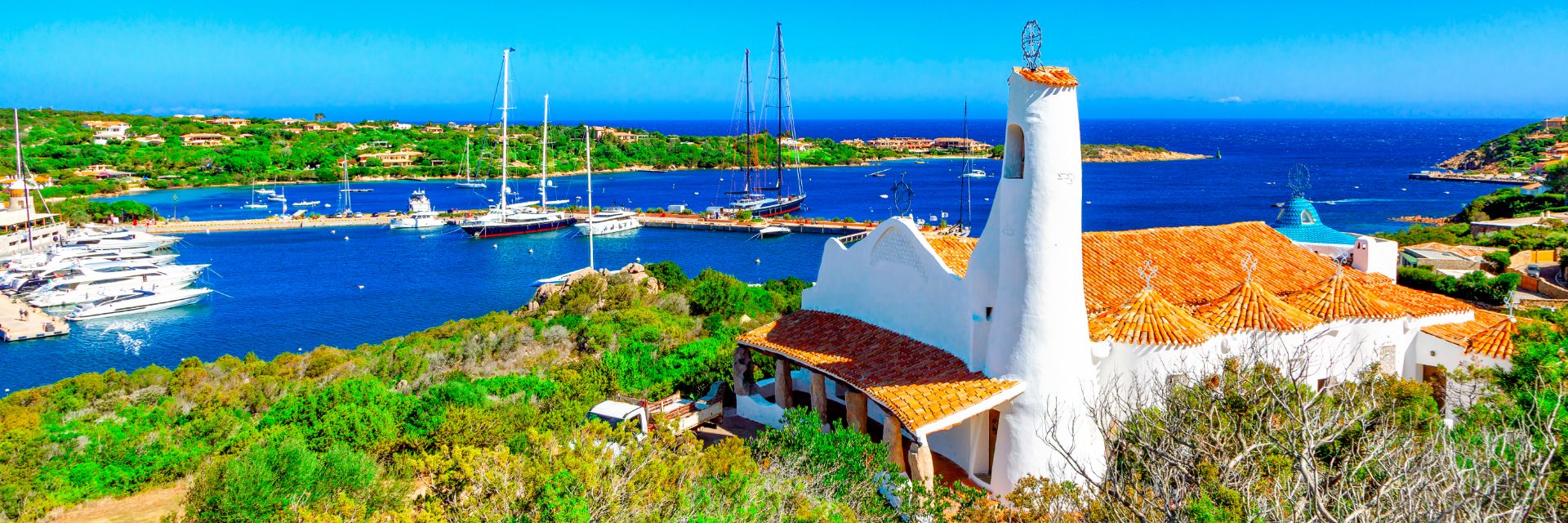 Deep blue waters meet a bright green coastline.