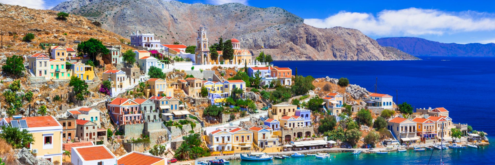 Bright blue skies and water surround stone buildings. 