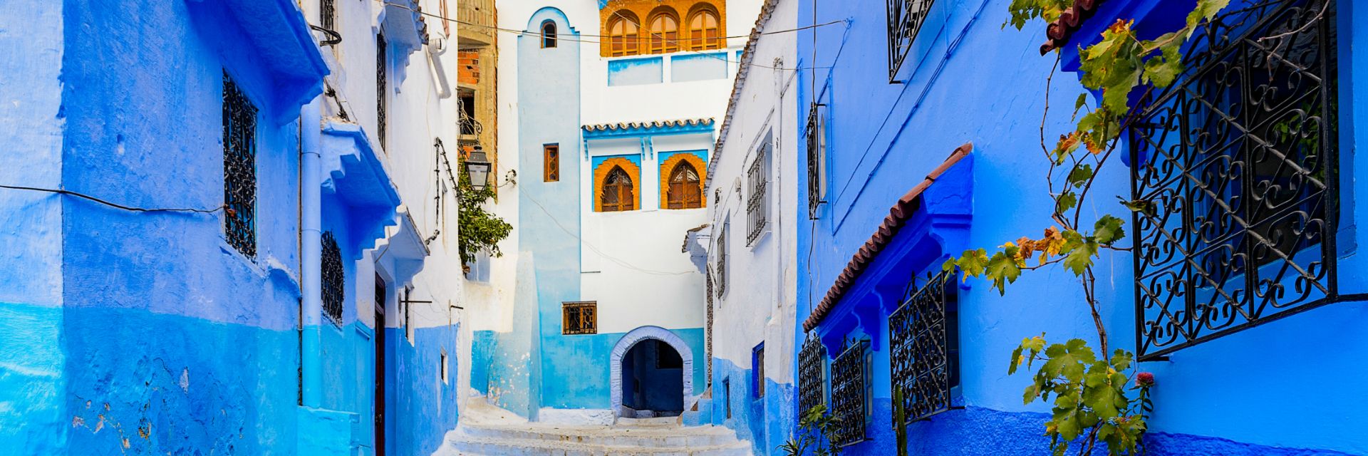 Bright blue walls line a stone walkway.
