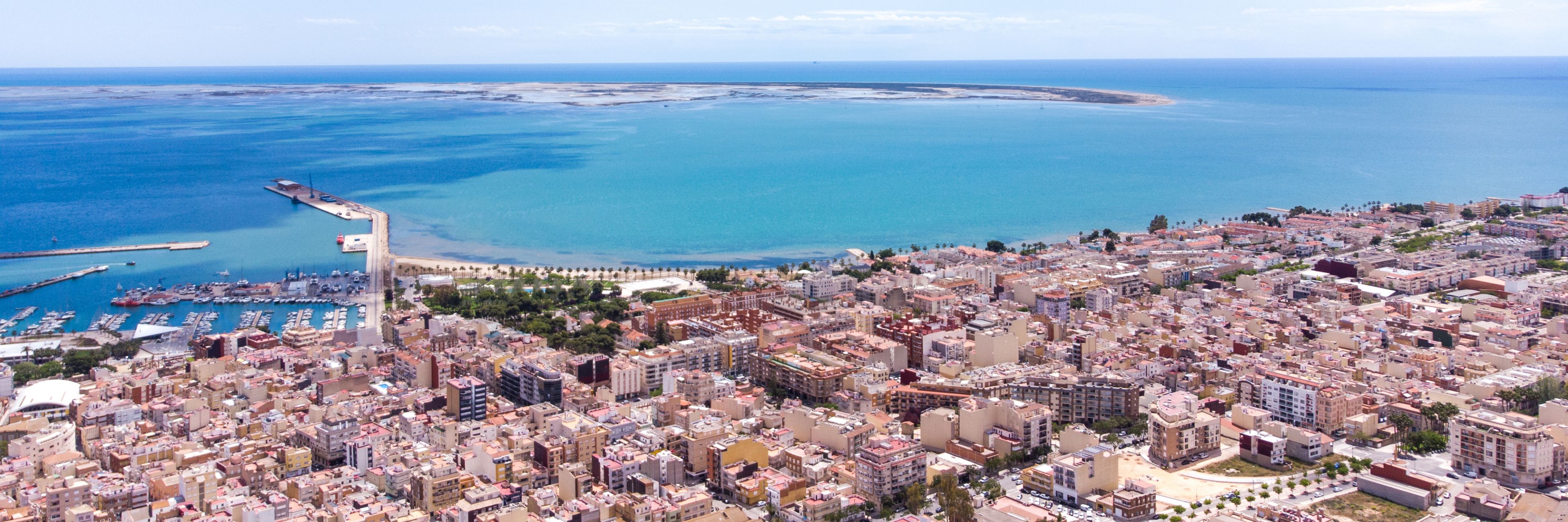 Buildings fill La Rapita, Spain with the ocean in the background.