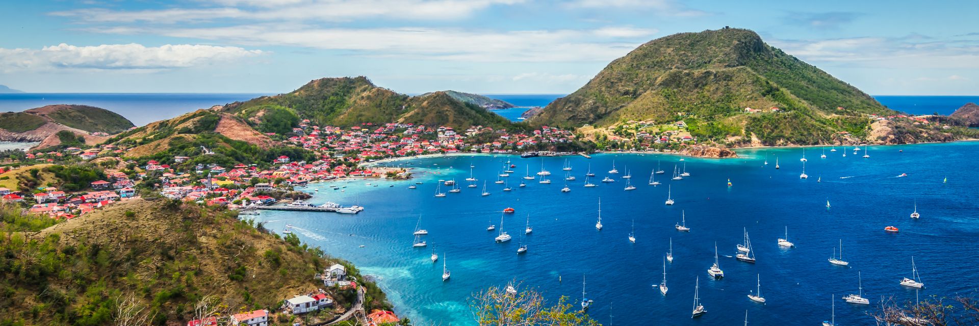 Boats fill an inlet floating through deep blue waters.
