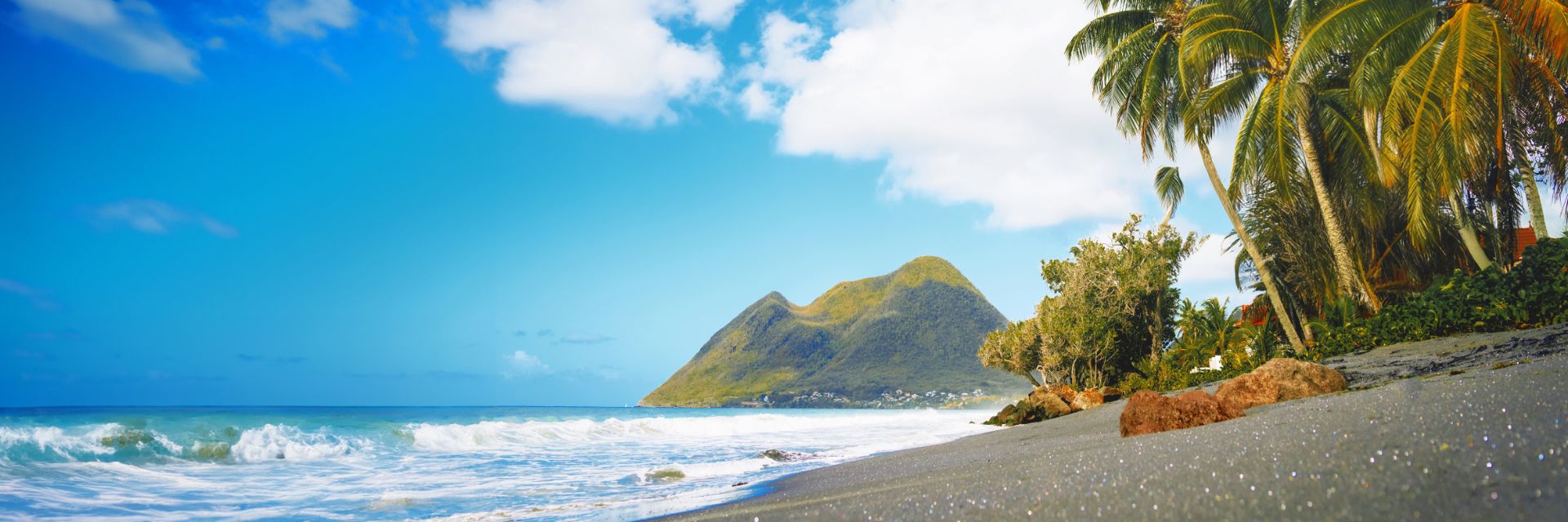 Sand shines on a beach sitting under bright blue skies.