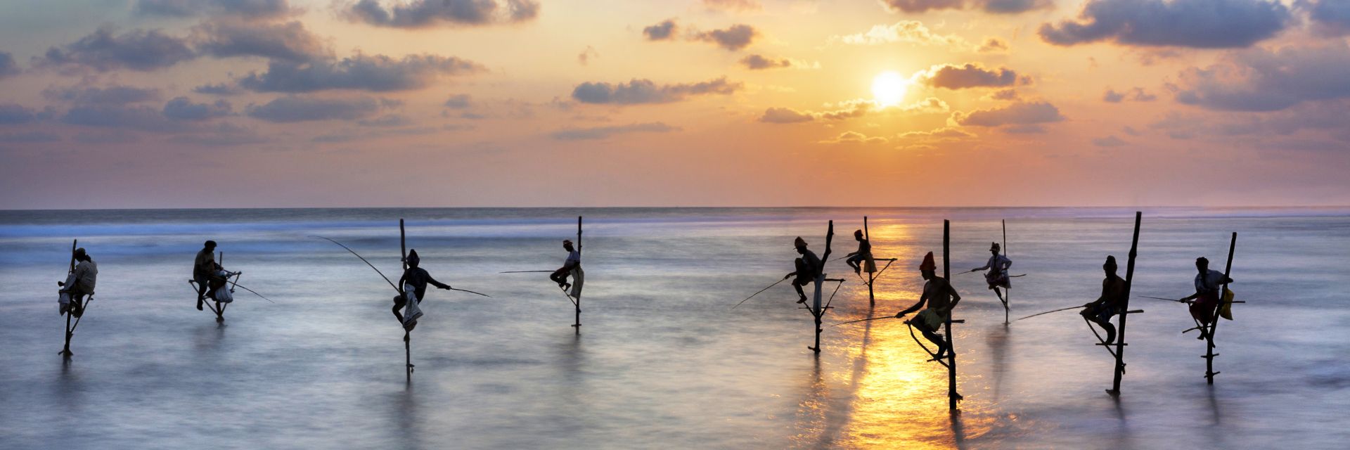 Sunset/Sunrise on beach with fishermen in water
