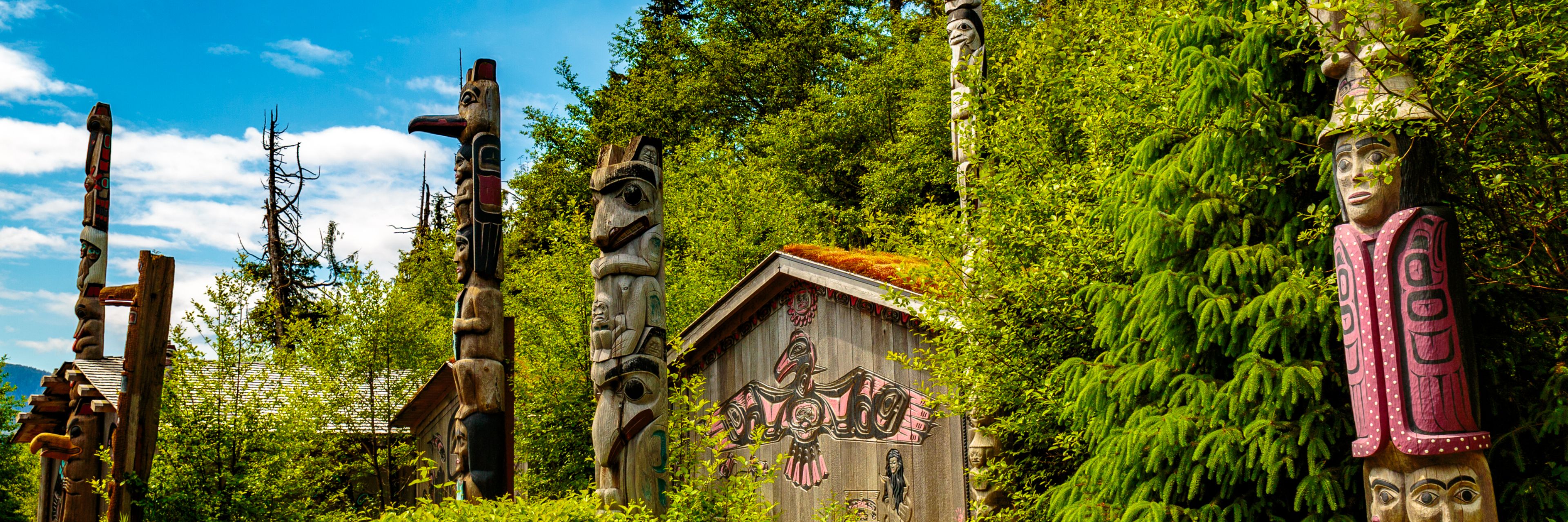 Totems sit surrounded by bright green foliage.