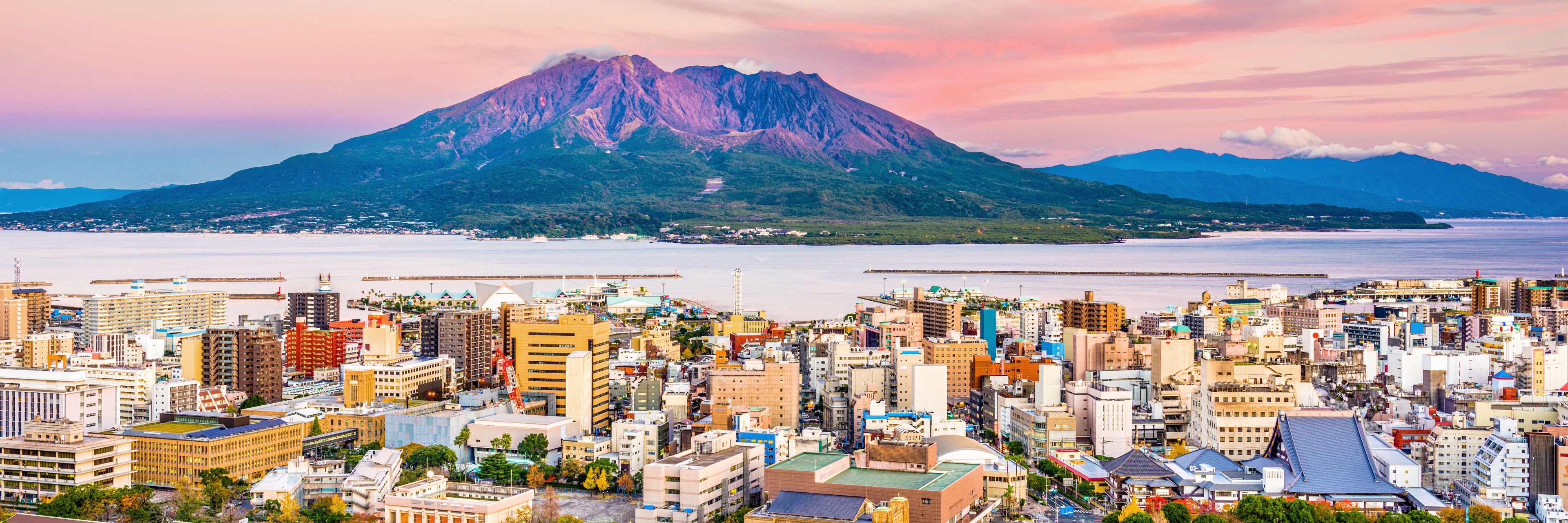 The sun sets on a small town on the water.