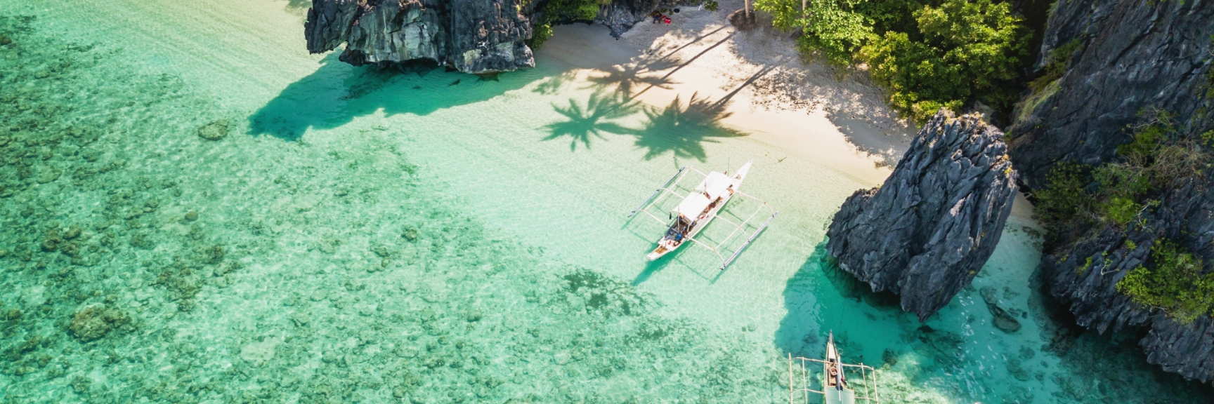 Boats near a mountainous beach. Hong Kong to Singapore. 