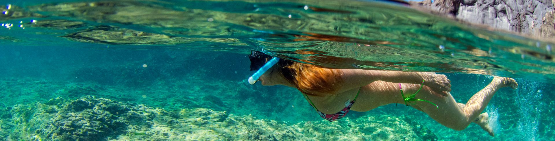 Woman snorkeling underwater in the ocean.
