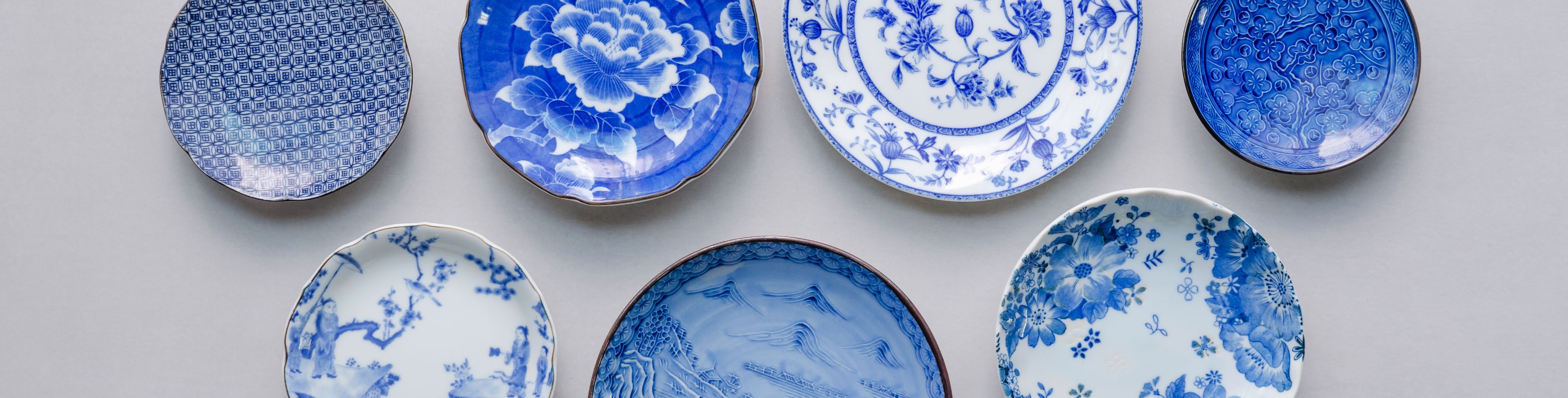 Various china plates laid on a counter. 