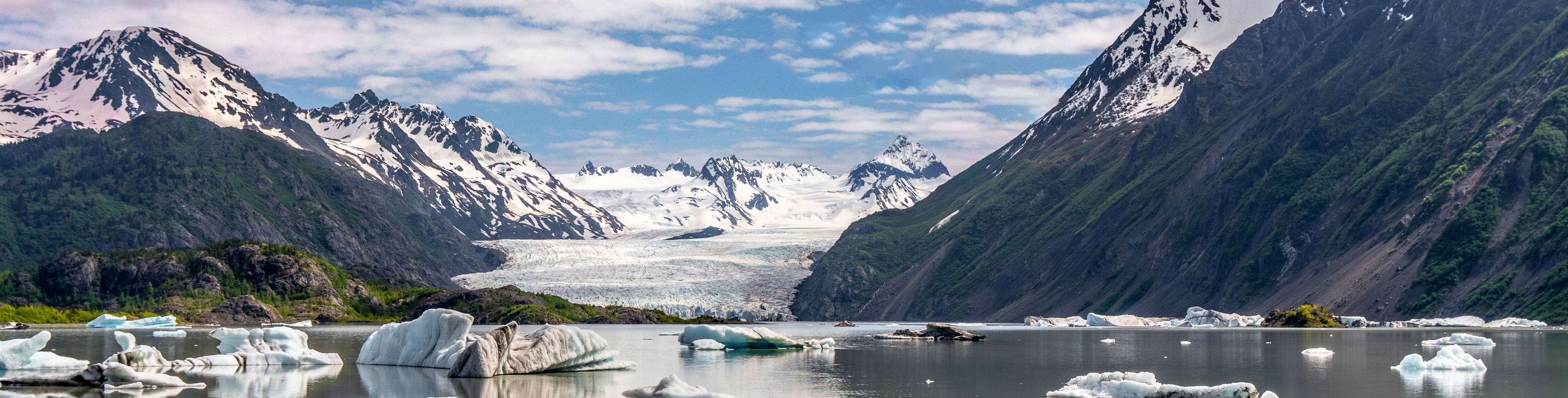 Ice and snow on water, between two mountains in a valley.