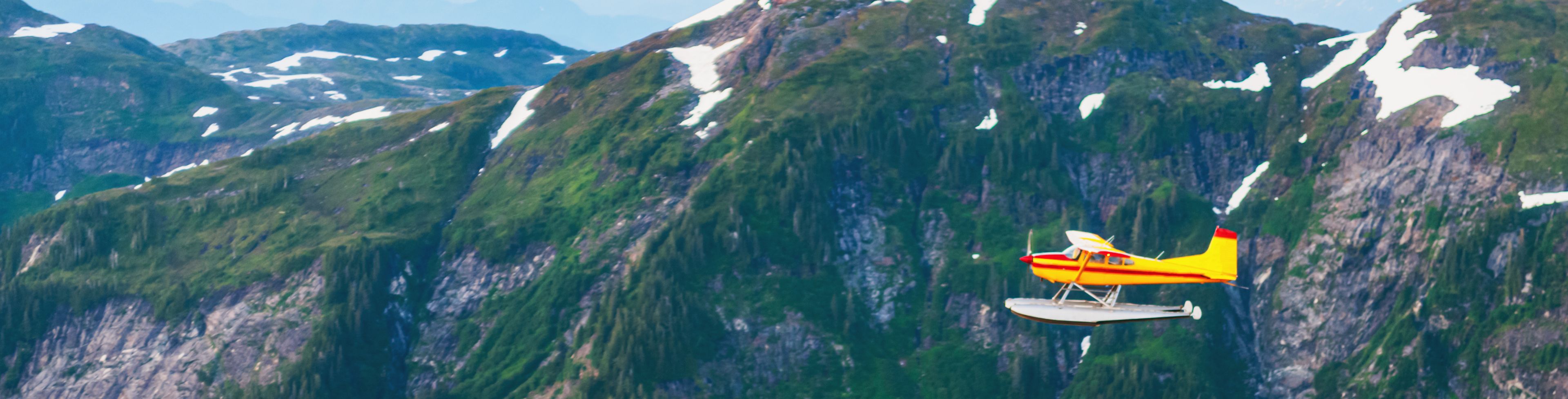 Seaplane flying by mountains. 