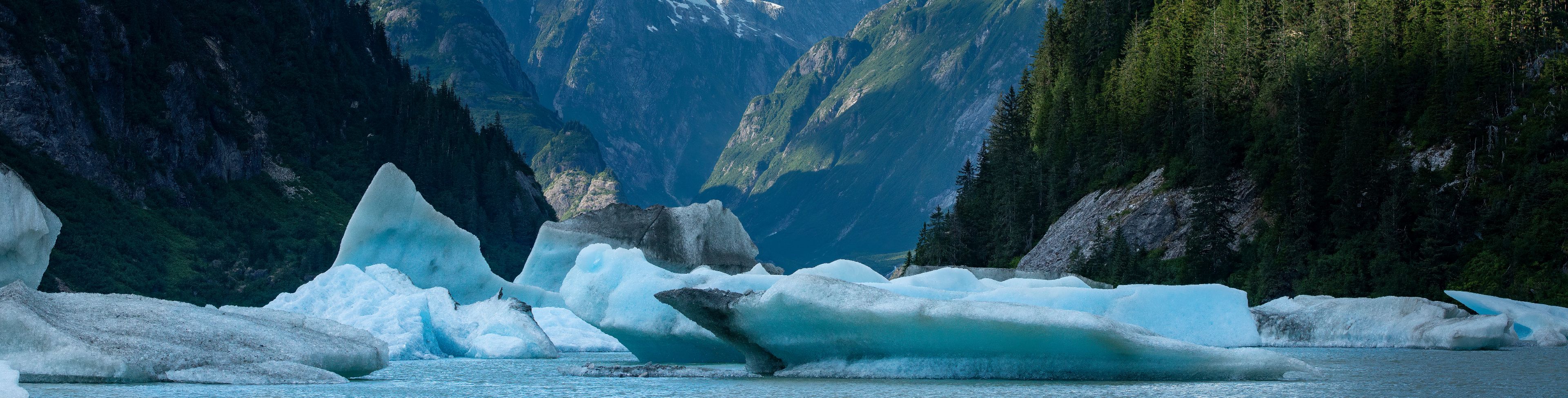 Glaciers on water between a valley of mountains. 