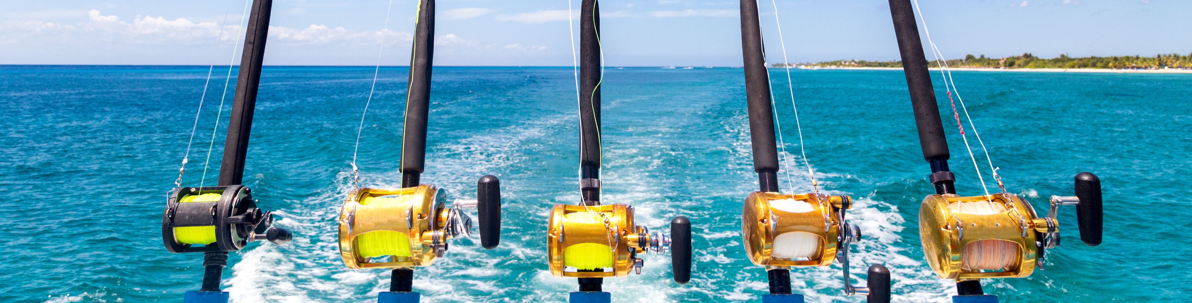 Five fishing poles, attached to the back of a moving boat. 