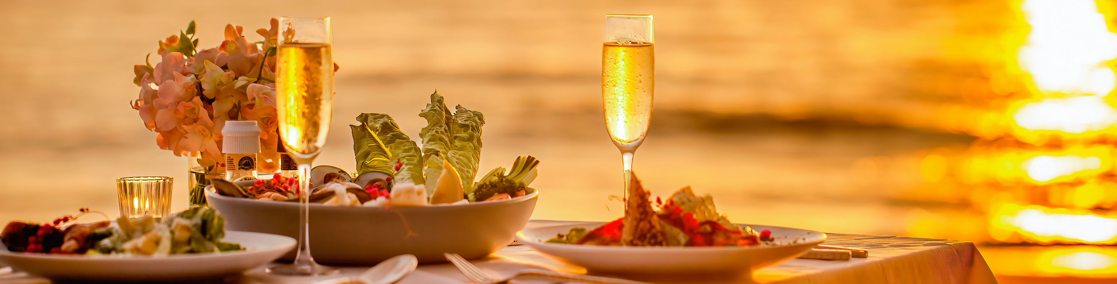 Table set at sunset, overlooking the ocean. 