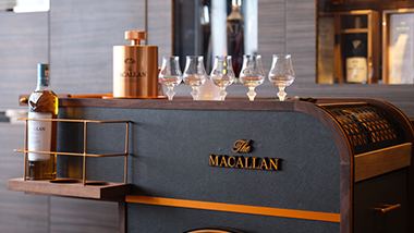 Wine glasses lines up on a bar. 