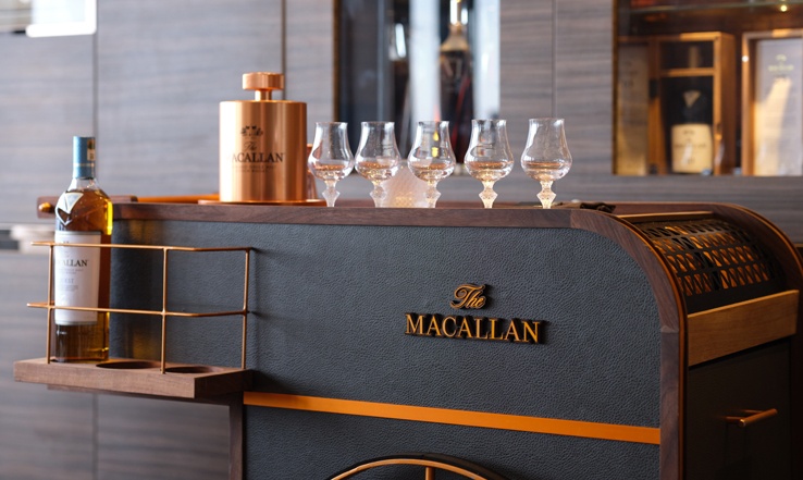 Wine glasses lines up on a bar. 