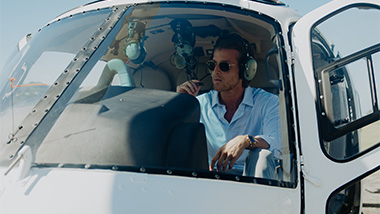 Man sitting in helicopter with his headset on. 