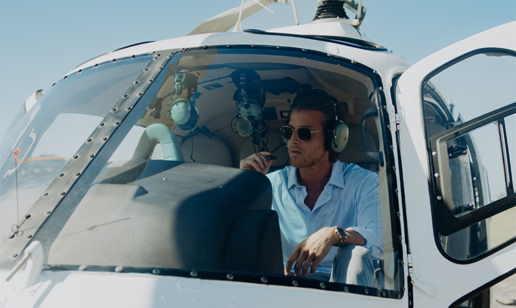 Man sitting in helicopter with his headset on. 