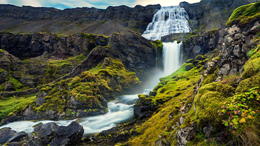 Waterfalls down a valley from a mountain. 