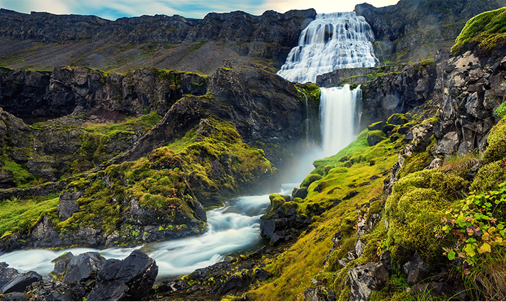 Waterfalls down a valley from a mountain. 