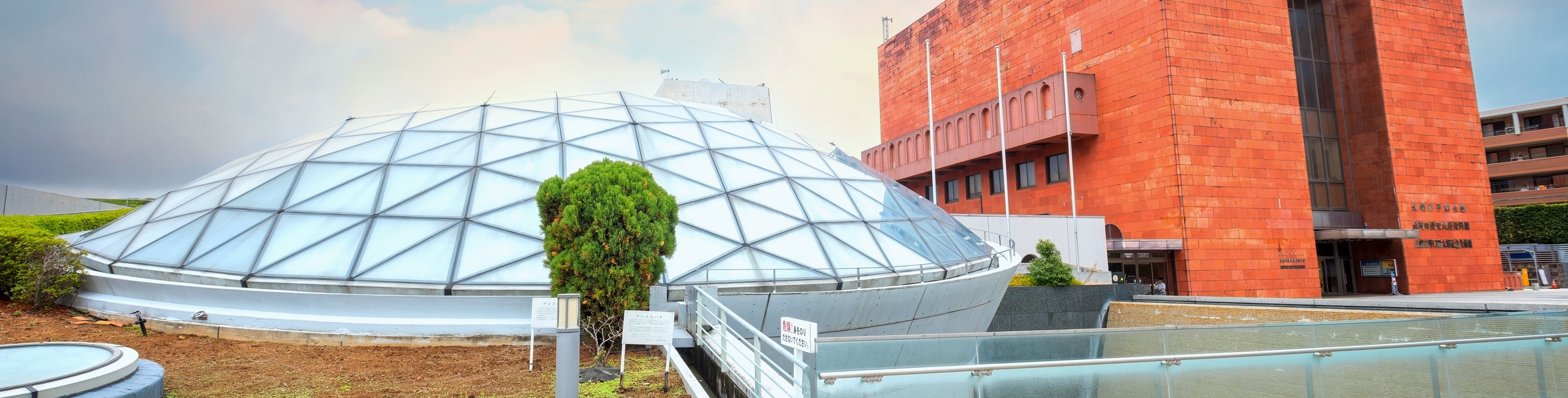 Buildings, one with a glass dome and the other built from brick. 