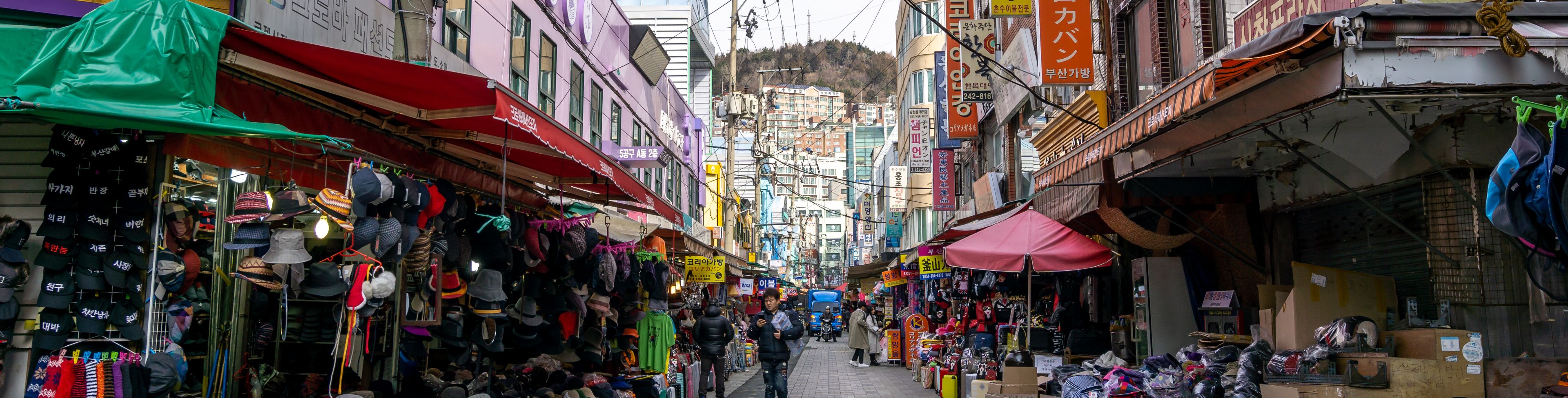 Bustling market with people at different market stalls. 