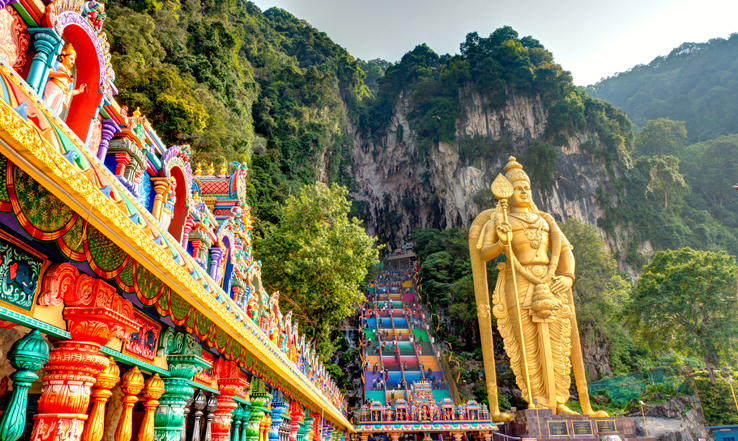 Statue and Hindu temples leading up a mountain side. 
