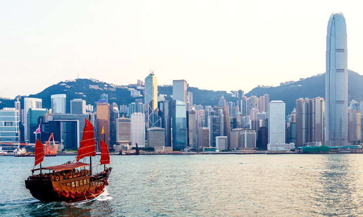 A boat going towards the Hong Kong city in the distance.