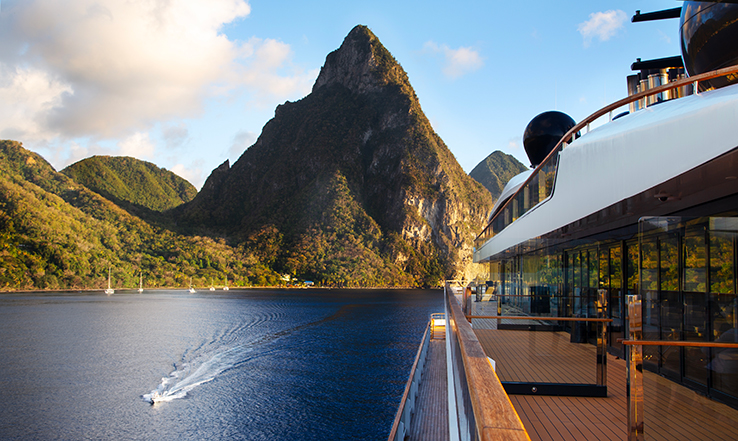 Small boat boating in the water beside a large yacht.