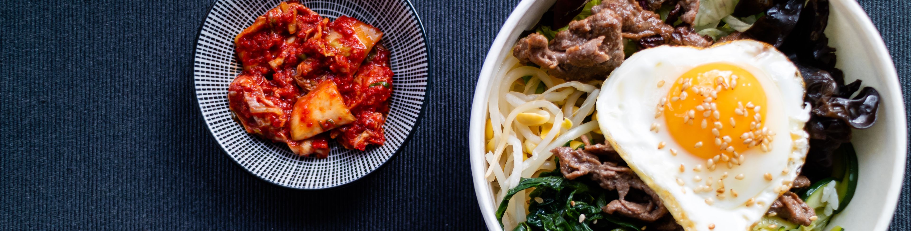 One large bowl of food and another small bowl of red food. 