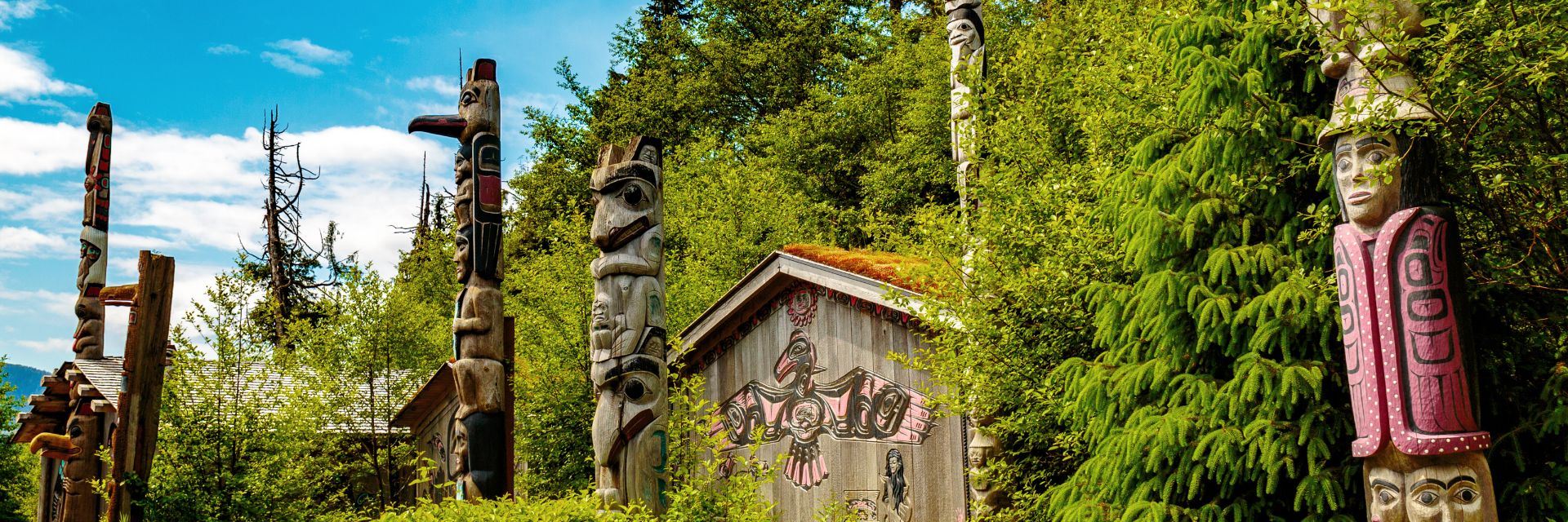 Totems sit surrounded by a forested area. 