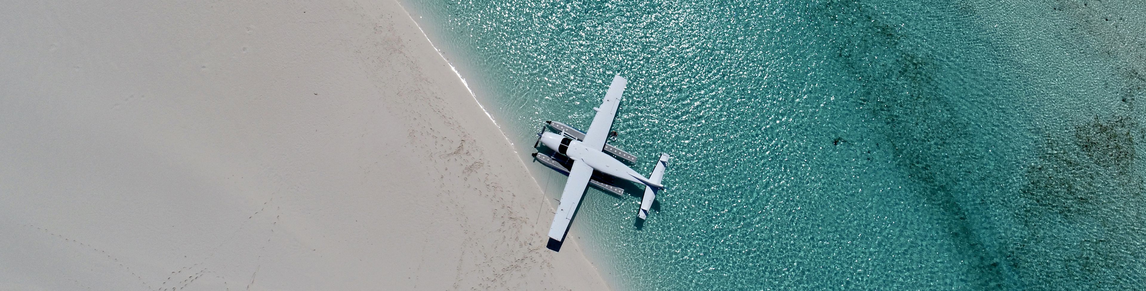 Water plane parked on the edge of water connecting to the shore. 