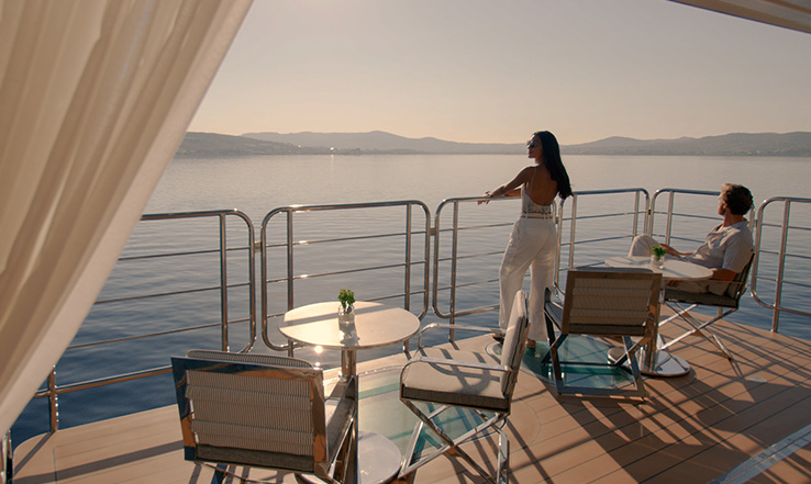 Man and woman on a deck, looking out towards the ocean.